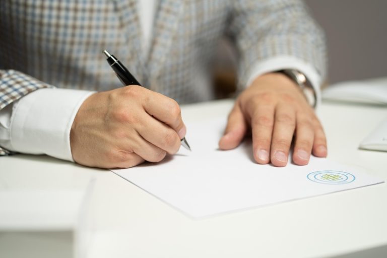 A man signing a document with a pen