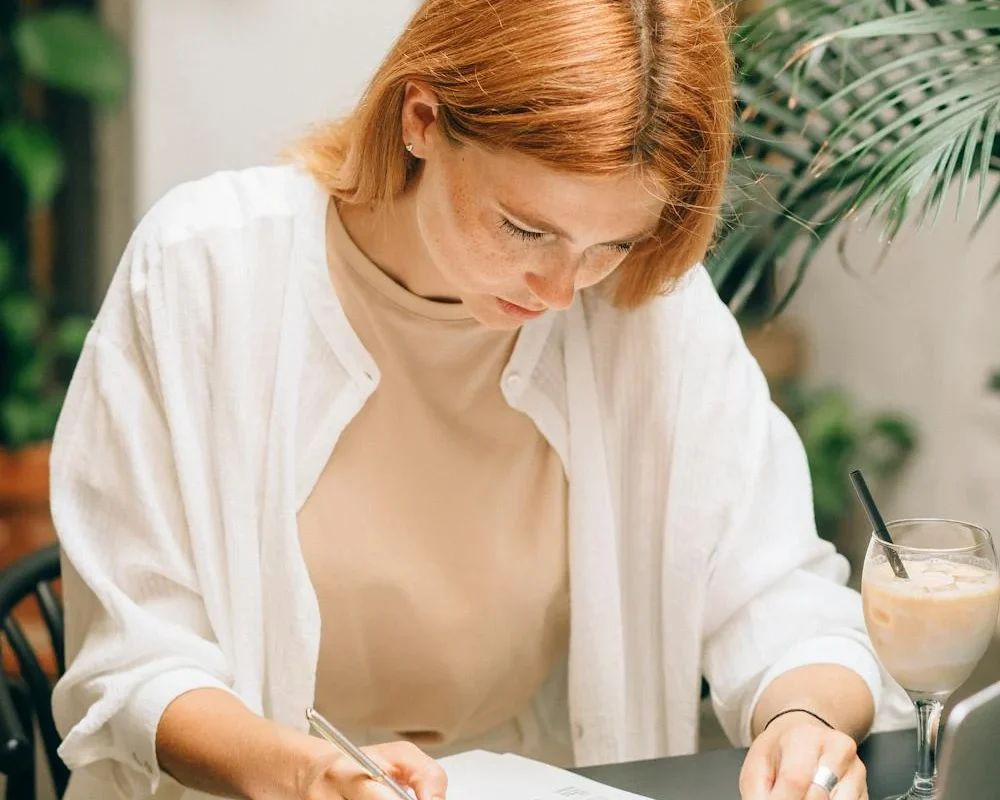 Jeune femme concentrée sur l’analyse de documents à son bureau