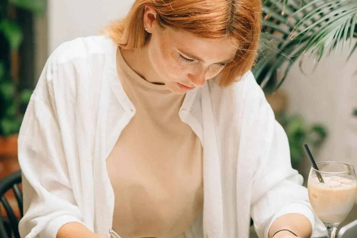 Jeune femme concentrée sur l’analyse de documents à son bureau